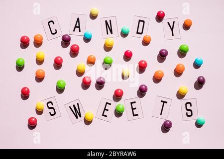 Birthday Concept . Holiday Food Top View Various Sweet Candies on pink Background. Fun Decoration. Minimal Holiday Concept. Pattern lollipops, candy