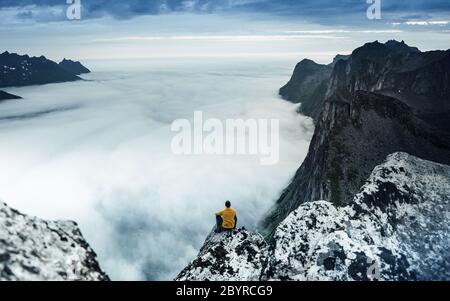 Life on the edge. Traveler on a cliff above a fjord enjoying Norway. Landscape travel lifestyle success motivation concept adventure active vacation Stock Photo