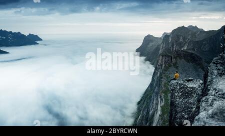Life on the edge. Traveler on a cliff above a fjord enjoying Norway. Landscape travel lifestyle success motivation concept adventure active vacation Stock Photo