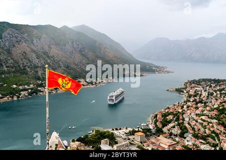 Montenegrin flag and large cruise ship in the Bay of Kotor, Montenegro Stock Photo