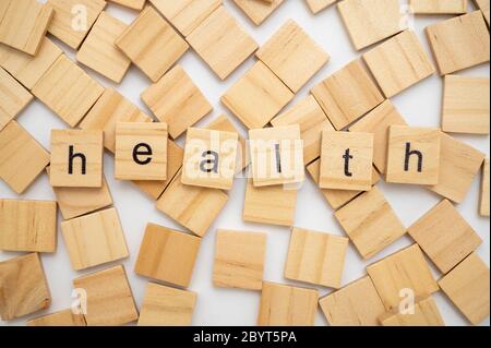 Wood letter tiles spelling word HEALTH lying on a pile of tiles Stock Photo