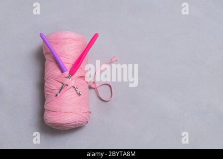 knitting pink crochet hooks and woolen thread on a blue background Stock  Photo - Alamy