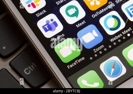 Mobile app icons of FaceTime, Microsoft Teams, Google Hangouts Meet, Zoom, and Cisco Webex Meetings are seen on an iPhone. Stock Photo