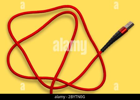 USB cable on a yellow background. The wire for the phone, charging cord for the computer. Stock Photo