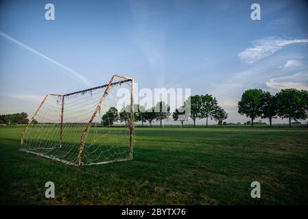 soccer football goal in rural country sunrise on local town village green pitch Stock Photo