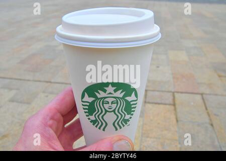BRATISLAVA, SLOVAKIA - JUNE 8, 2020: An Unidentified man hand holding a cup of beverage from Starbucks cafe. Close-up. Stock Photo