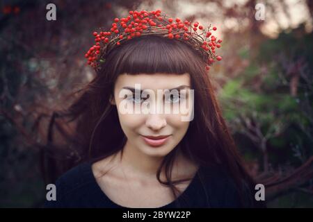 Beautiful girl with crown of red berries . Seasonal outdoor portrait Stock Photo