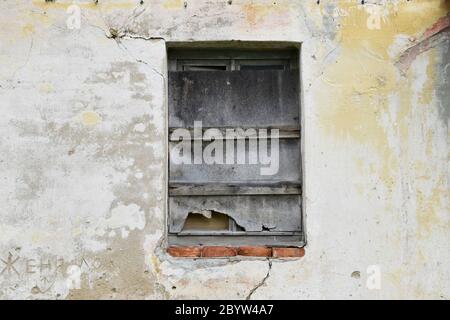 Boarded building window with burnt discolored planks. Stock Photo