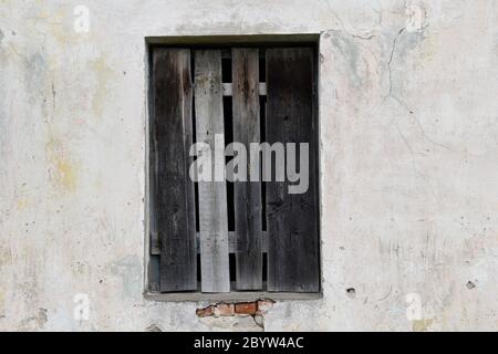 Boarded building window with burnt discolored planks. Stock Photo