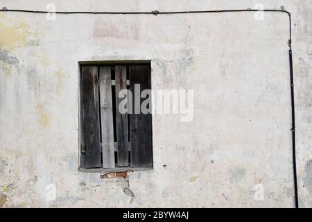 Boarded building window with burnt discolored planks. Stock Photo