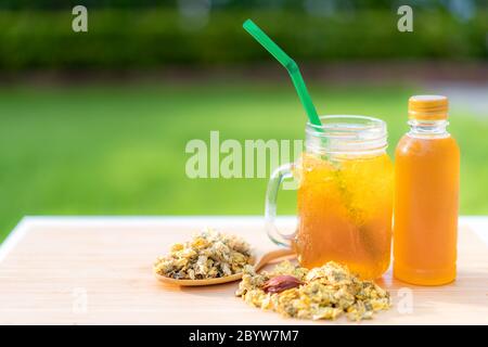 Cold water of chrysanthemum flowers and dried chrysanthemum flowers on wooden table chinese Thai herb juice and refreshment cold drink. Stock Photo