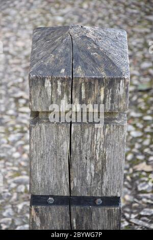 Cracked wooden post on stone floor Stock Photo