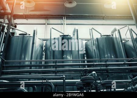 Large steel industrial stainless steel vats in modern brewery, toned Stock Photo