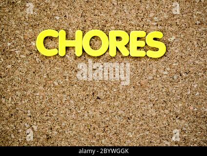 an empty brown cork board with the word 'CHORES' at the top in yellow letters with empty space for customized message Stock Photo