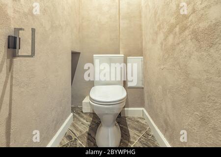 White built in toilet bowl in modern bathroom with paper holder and toilet brush Stock Photo