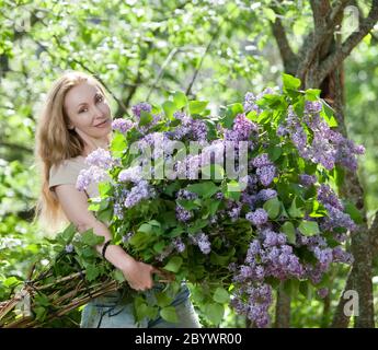 The girl in park with a huge bouquet of a lilac Stock Photo