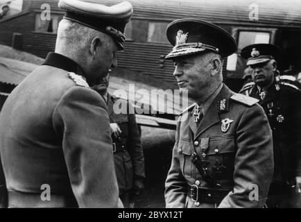 Marshal Erich von Manstein (left) welcomes Marshal Ion Antonescu, Prime Minister of Romania, to the field airfield. In the background, a visible fragment of the Junkers Ju-52 transport aircraft ca. June 1943 Stock Photo