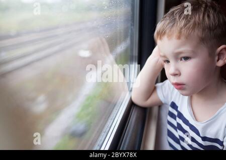 Boy looking out the window of train Stock Photo
