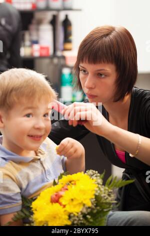 Young boy getting haircut from styist Stock Photo