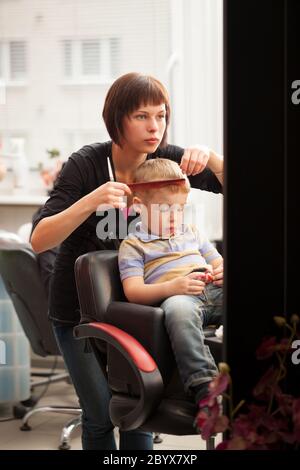 Little boy getting a haircut from hairdresser Stock Photo