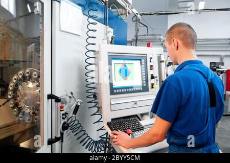 worker operating CNC machine center Stock Photo