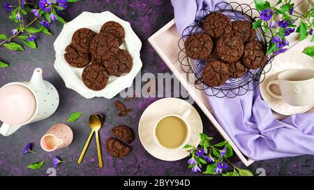 Serving freshly baked double chocolate chip homemade cookies on pink tray with tea and coffee, creative concept flat lay. Top view overhead. Stock Photo