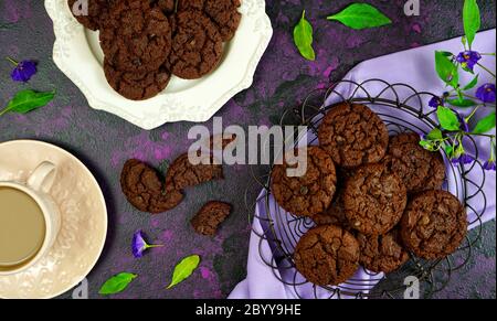 Serving freshly baked double chocolate chip homemade cookies on pink tray with tea and coffee, creative concept flat lay. Top view overhead close up. Stock Photo
