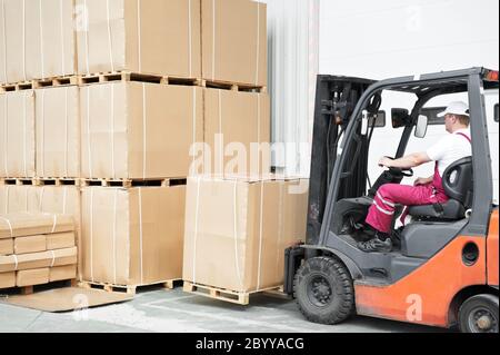 worker driver at warehouse forklift loader works Stock Photo