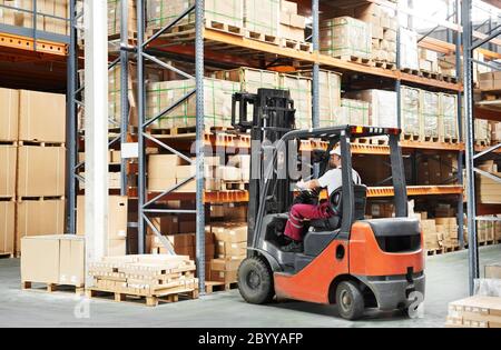 worker driver at warehouse forklift loader works Stock Photo