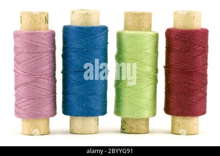 four colorful thread spools Stock Photo
