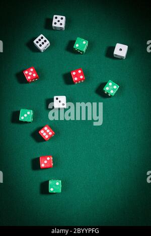 Multi-colored dice on a playing table with green cloth Stock Photo