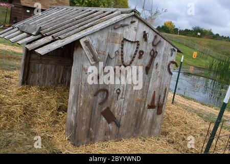 Antique farm tools hanging on a wall Stock Photo