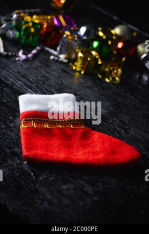 Red christmas sock on dark wooden background. Concept of christmas or holiday. Stock Photo