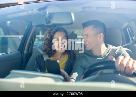 Man looking at a woman, both sitting in a car Stock Photo