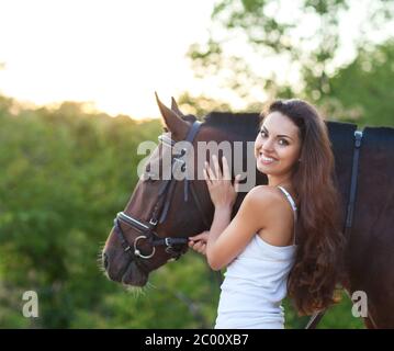 Portrait beautiful woman with long hair next horse Stock Photo