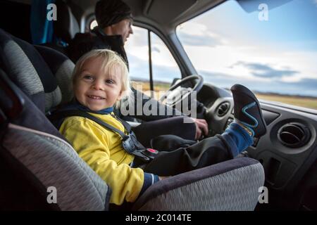 Cute toddler boy kid sitting on the front seat in child seat on big camper van smiling happily Stock Photo Alamy