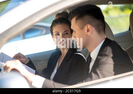 Young pretty woman and man in business suits in car Stock Photo