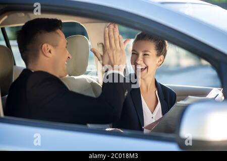 Happy woman and man touching welcoming in car Stock Photo