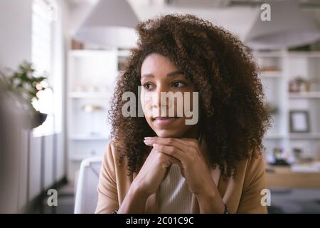 Portrait of a mixed race businesswoman thinking and smiling Stock Photo