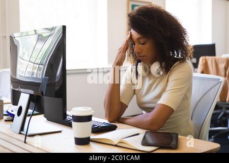 Mixed race woman working hard on computer in an office Stock Photo