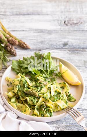 tagliatelle with spinach and asparagus. pasta with cream sauce and vegetables Stock Photo