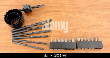 Hole saw and drill bit set on a wooden background Stock Photo