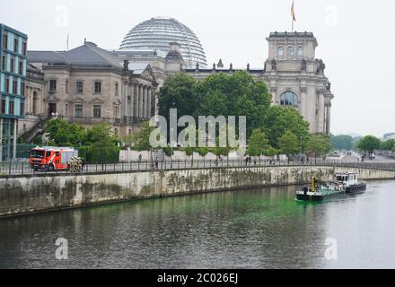 11 June 2020, Berlin: Emergency fire brigade units are standing in the Berlin government district on the banks of the Spree River, where parts of the water have been dyed poisonous green with the dye uranine by activists of Extinction Rebellion (XR) during the 'Coal Poisoned' campaign to draw attention to the far-reaching damage caused by coal mining to people and the environment. Credit: dpa picture alliance/Alamy Live News Stock Photo