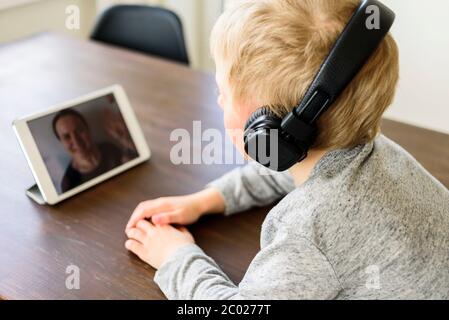 Child having video call to mother using tablet. Family communicating through the Internet Stock Photo