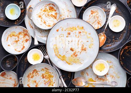 Dirty plates, bowls and cutlery after a meal Stock Photo