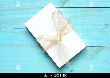 Blank papers to write letters tied with a raffia ribbon on an old white wooden table Stock Photo
