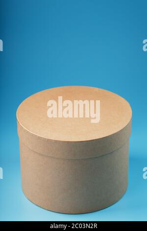 Round cardboard box on a blue background, free space. Stock Photo