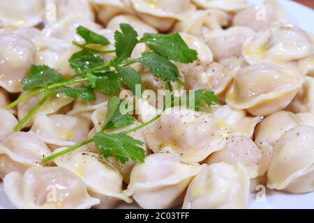 Ready pelmeni submitted with butter, parsley and strewed by ground pepper Stock Photo