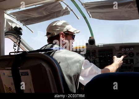 A  pilot of a Pilatus aircraft making a turn prior to landing at an airtstrip in the Sahara desert. Stock Photo