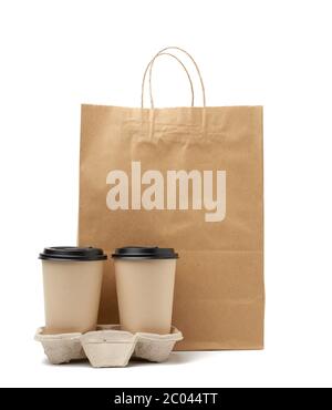 brown paper craft bag and disposable cups for hot drinks in tray are isolated on white background, packaging for delivery Stock Photo